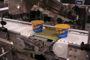 powered transfer display transfer of instance Mac and cheese cups across conveyor belts
